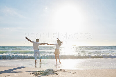 Buy stock photo Back, couple and holding hands with freedom by beach for travel adventure, honeymoon vacation and dancing. Sky space, people and bonding at seaside for anniversary holiday, summer break and enjoyment