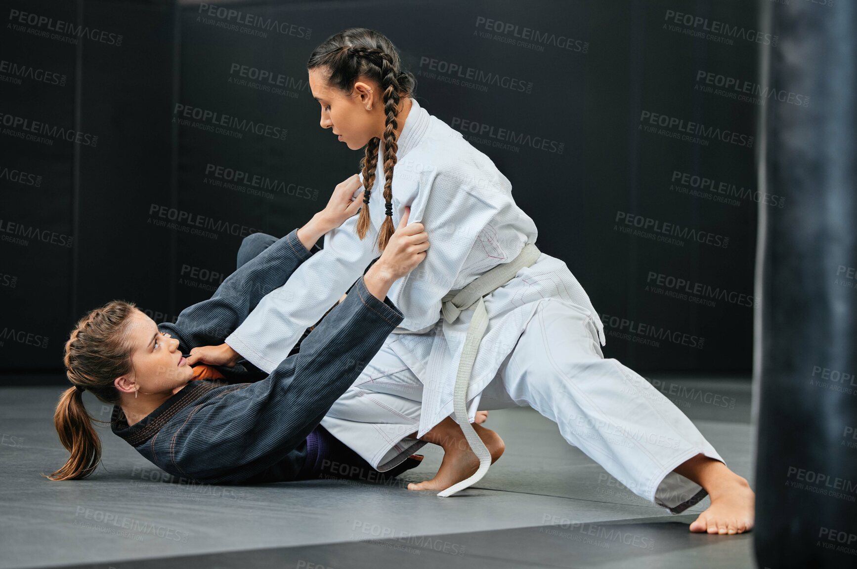 Buy stock photo Mma, karate and jiu jitsu with two female athletes practicing, training and sparring in fight class. Healthy, fit and active women in gi or uniform learning self defense for safety and health