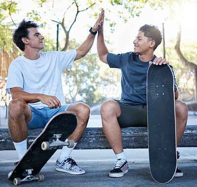 Buy stock photo High five, skateboard and skater friends at city skatepark, young men sitting in park and celebration of achievement. Freedom, urban fun and happy gen z men hands celebrate skate trick goals