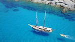 Boat, sailing in blue water and summer sun on ocean holiday, relax in freedom and nature. Yacht vacation, aerial of travel and tropical cruise on adventure to Greek island with sunshine, fun and sea.