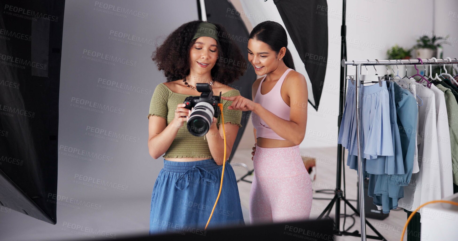 Buy stock photo Employees, camera and direction with photoshoot on set, collaboration and instructions for shooting. Women, photographer and speaking to model for filming feedback, review image and backstage project