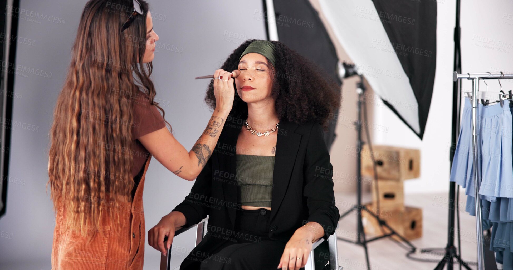 Buy stock photo Makeup, stylist and prepare woman for photoshoot, behind the scene and process for production. Cosmetics, blush powder and crew artist with skills for glamour, apply highlighter and touch up model