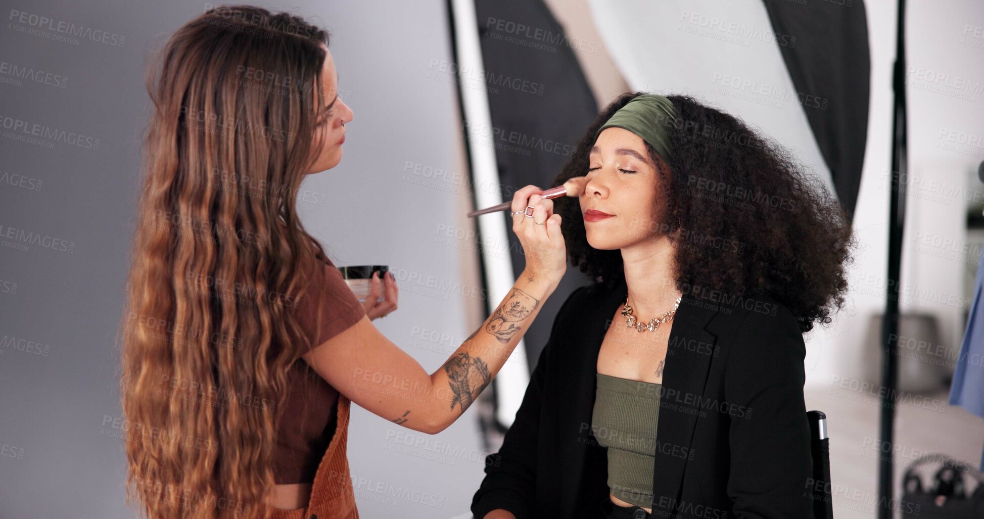 Buy stock photo Makeup, studio and prepare woman for photoshoot, behind the scene and process for production. Cosmetics, blush powder and crew stylist with skills for glamour, apply highlighter and touch up model