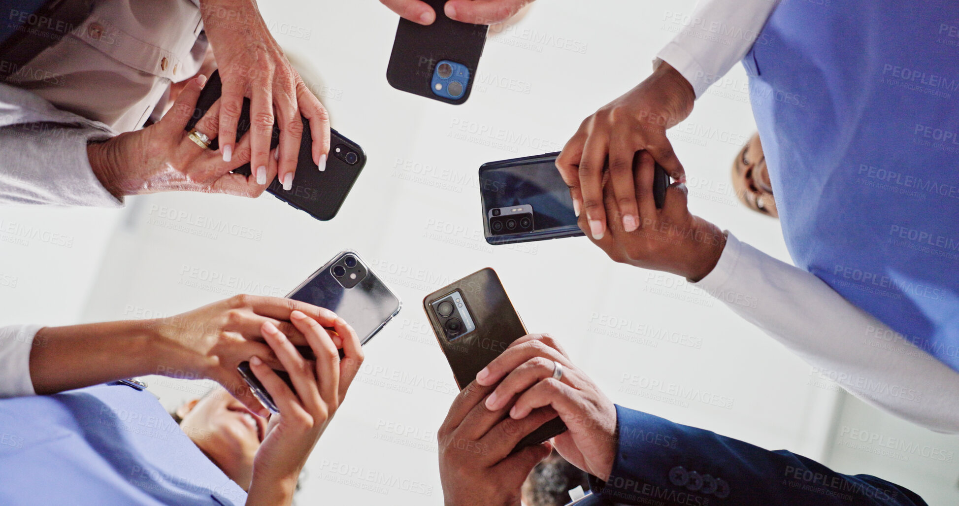 Buy stock photo Doctor, hands and meeting below with phone for data sync, research or telehealth at hospital. Low angle, group or healthcare employees in circle with mobile smartphone for sharing network at clinic