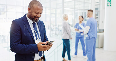 Buy stock photo Happy, businessman or investor with phone for medical funding, online investment or healthcare campaign at hospital. Man, board director or shareholder with smile on mobile smartphone for health app