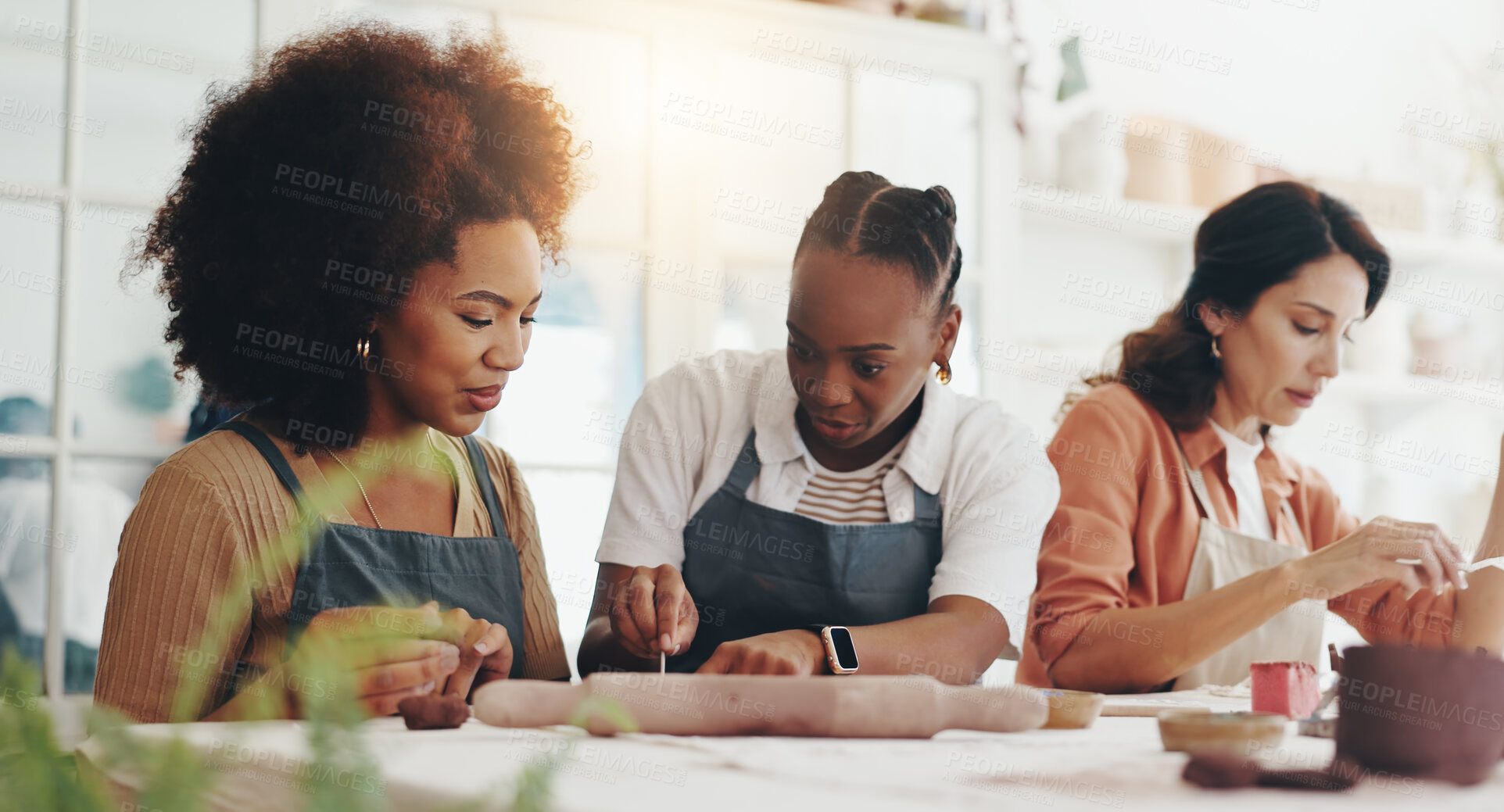 Buy stock photo Women, together and teacher at pottery class with guide, development or creativity at workshop. People, listening and advice with course, lesson and diversity with tools for sculpture in art studio