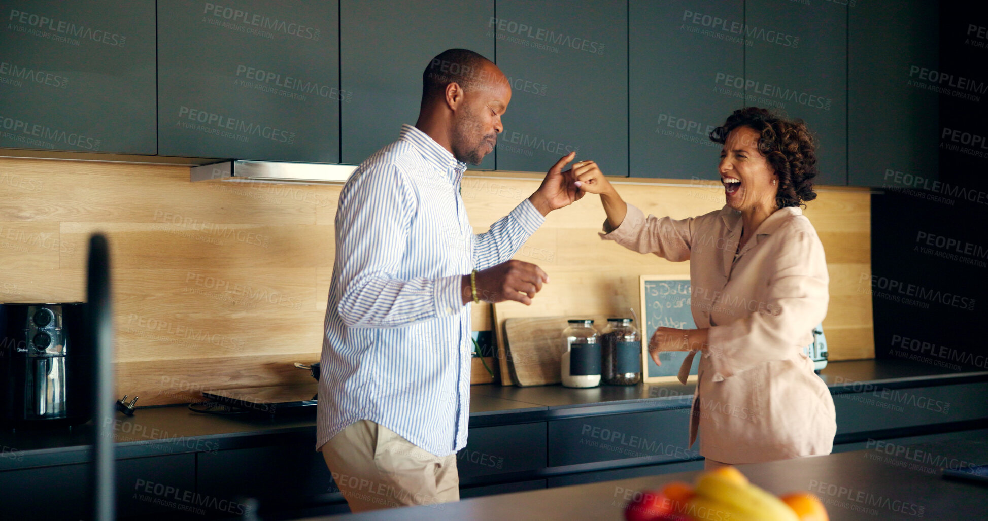 Buy stock photo Couple, laughing and dancing in home, love and playful romance in happy marriage. People, together and holding hands for commitment joy in relationship, funny humor and silly fun for connection
