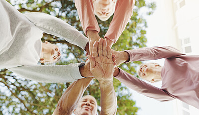 Buy stock photo Outdoor, senior people and hands with huddle for fitness, support and celebration together by below. Nature, retirement and friends with stack for solidarity, exercise goal or motivation by low angle