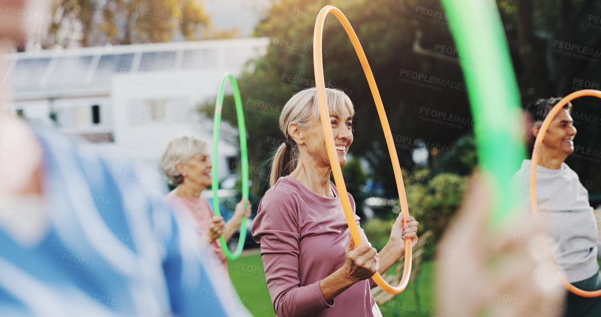 Buy stock photo Outdoor, senior people and exercise with hoop for physical fitness, wellness and rehabilitation. Retirement, coach and group of elderly women for training, workout and mental wellbeing with ring