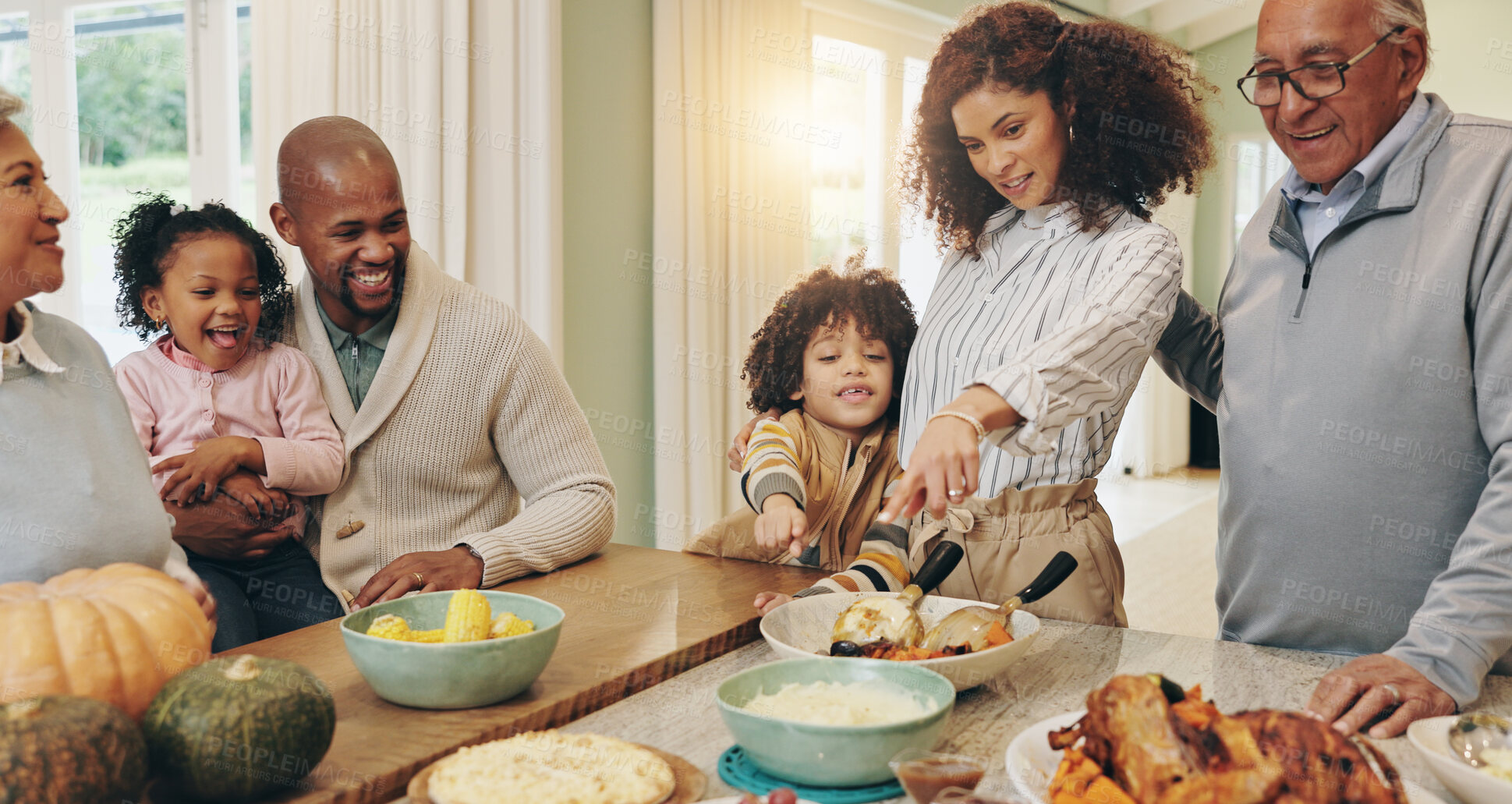 Buy stock photo Happy family, pointing and dining with children for thanksgiving dinner together by table at home. Grandparents, child and parents with smile, food or meal for bonding or holiday feast at house