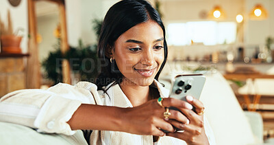 Buy stock photo Relax, smartphone and happy woman typing in home on app, reading blog or post comment on online forum. Living room, mobile and Indian girl chat on social media, notification or play game on internet