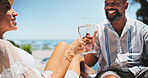 Couple, toast champagne and holiday on patio, relax or view by ocean, celebration or sunshine on valentines day. Mature people, man and woman for interracial love, drinks or vacation by sea in summer