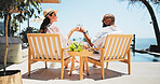 Couple, toast champagne and vacation on balcony, relax or view by ocean, celebration or cheers on valentines day. Mature people, man and woman for interracial love, drinks or holiday by sea in summer