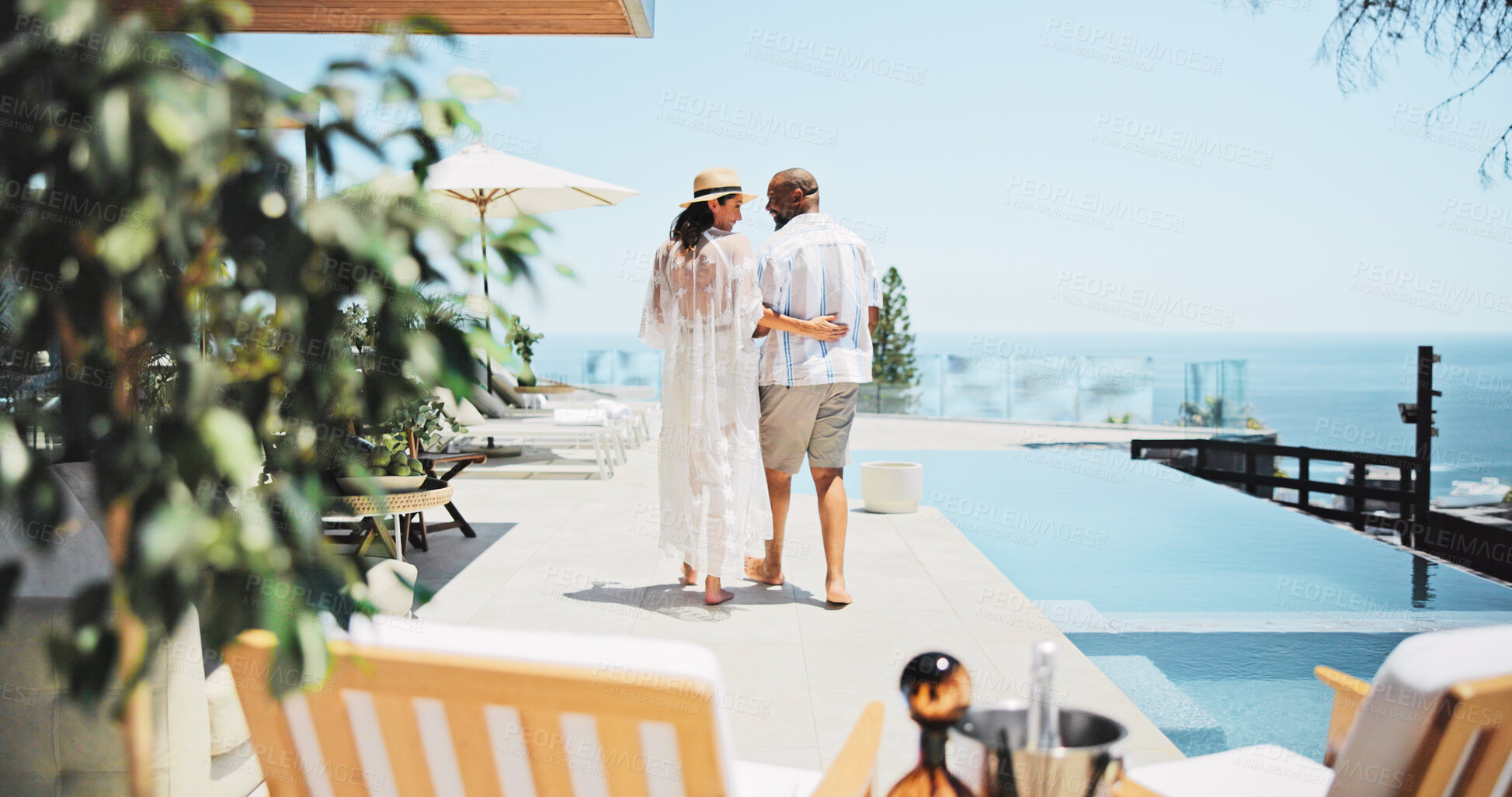 Buy stock photo Back, swimming pool and couple with vacation, view and bonding together with honeymoon. People, outdoor and man with woman, interracial and tropical island with hospitality, happiness or relationship