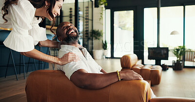 Buy stock photo Romance, interracial and mature couple in home, relax and laughing at joke in living room and comedy. Bonding, man and woman with love in relationship, funny and resting on break and comfortable