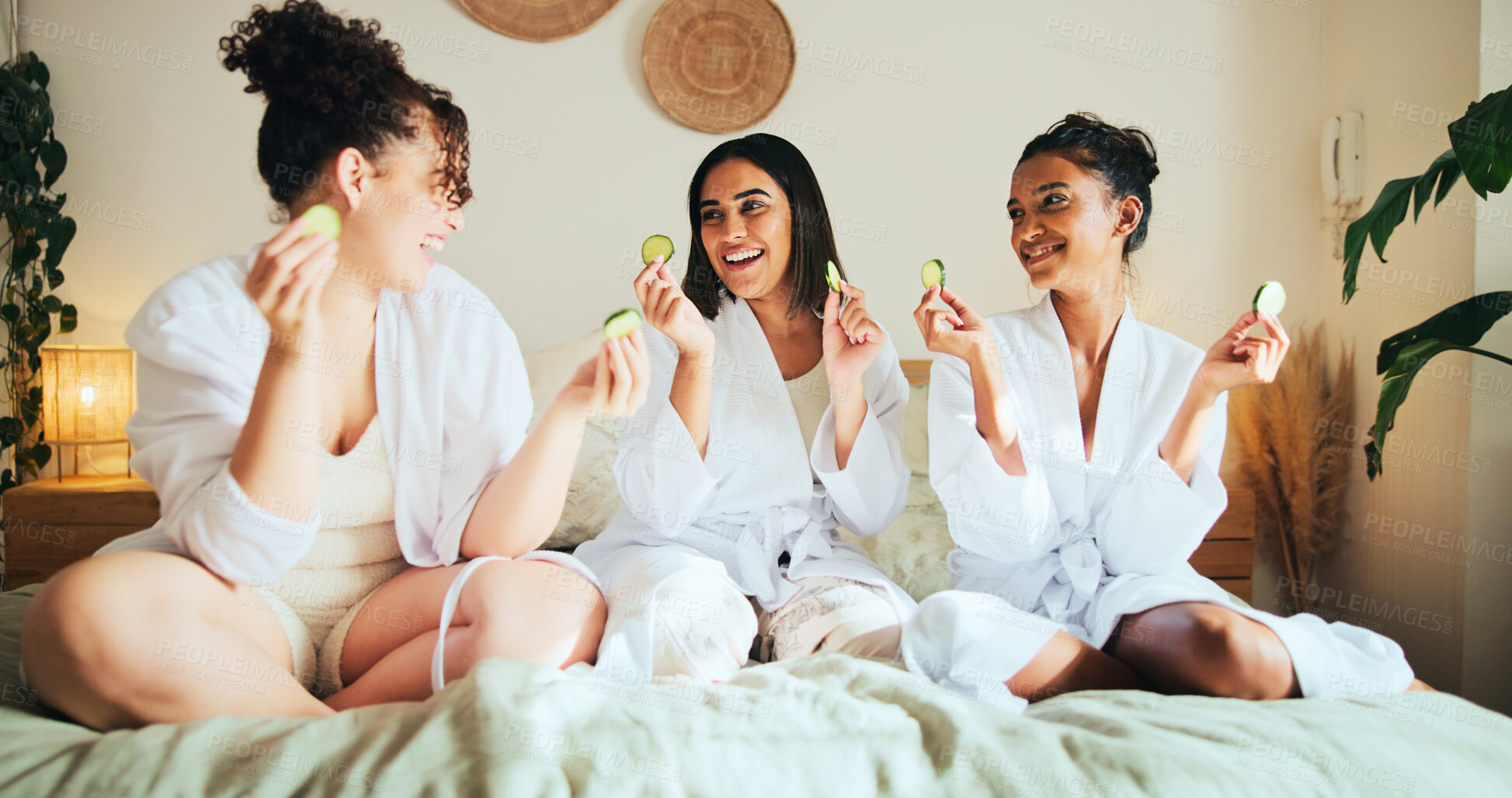 Buy stock photo Cucumber, skincare and friends with women in bedroom for beauty, spa day and dermatology. Facial, natural cosmetics treatment and hotel resort with people for self care, luxury and relax together
