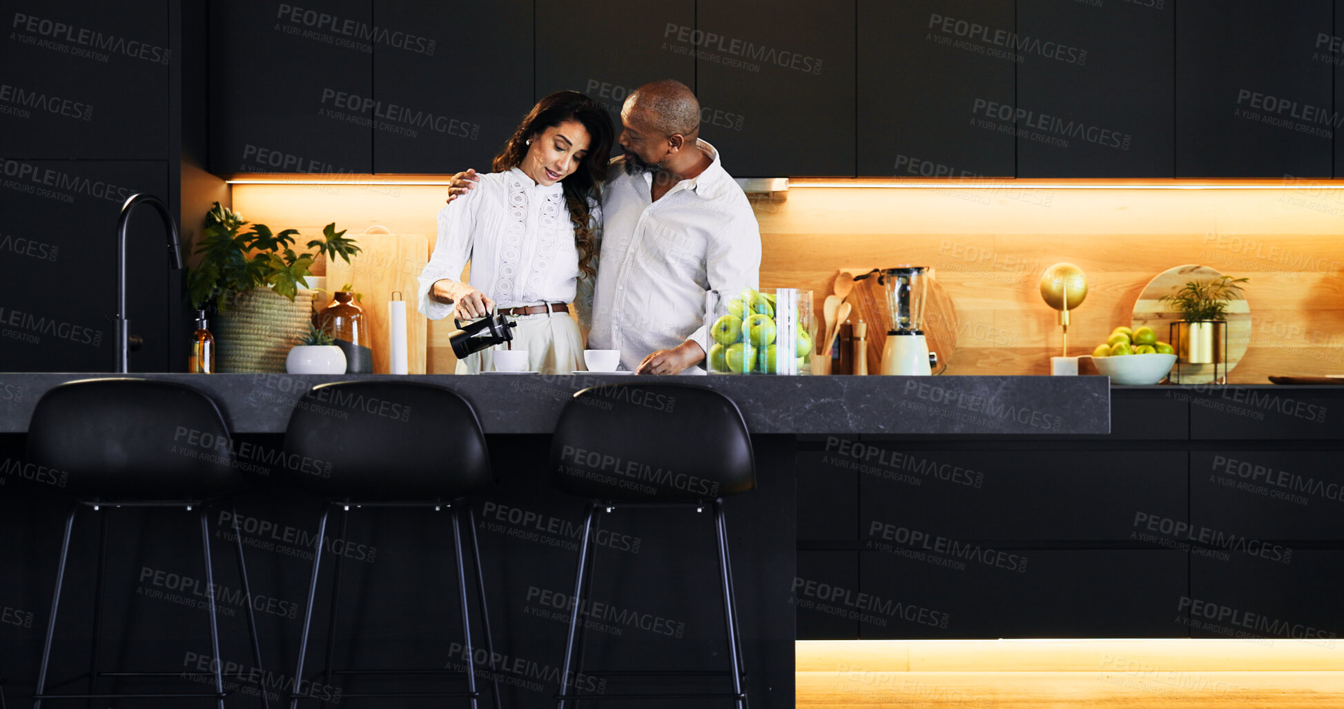 Buy stock photo Love, hug and coffee with interracial couple in kitchen for bonding, morning and romance. Happiness, support and care with man and woman at home for caffeine, marriage and valentines day