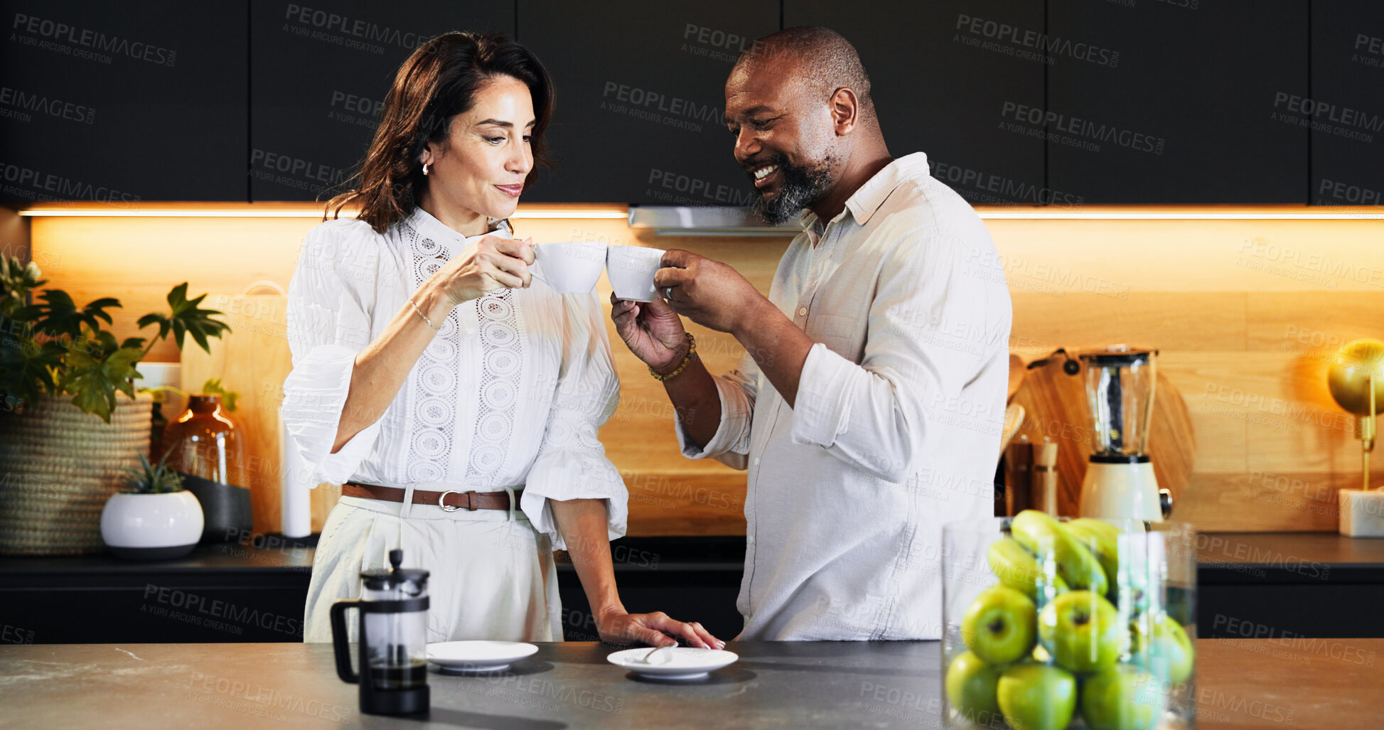Buy stock photo Mature, couple and cheers with coffee in kitchen of caffeine start, morning routine and bonding together. Interracial people, toast and beverage for celebration, marriage commitment and love at house
