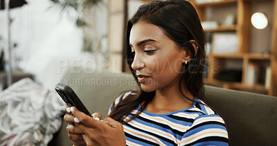Buy stock photo Phone, home and Indian woman on sofa for online chatting, social media and internet on weekend. Relax, apartment and person on smartphone for mobile app, connection and communication in living room