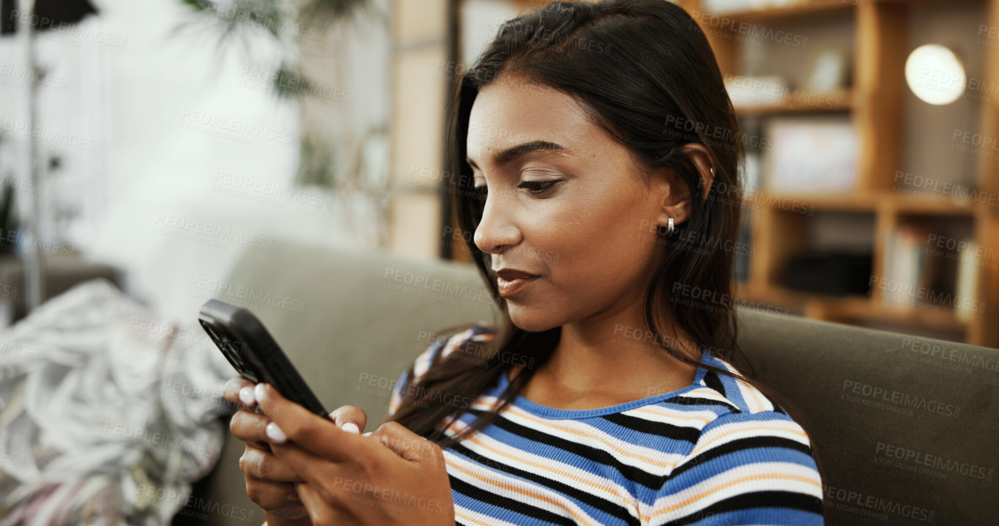 Buy stock photo Phone, home and Indian woman on sofa for online chatting, social media and internet on weekend. Relax, apartment and person on smartphone for mobile app, connection and communication in living room