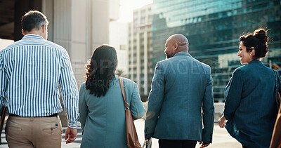 Buy stock photo Building, commute and collaboration with business people in city together for travel to work. Back, direction or group with man and woman corporate employees walking outdoor in urban town for journey