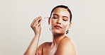 Woman, pride and skincare serum in studio for facial treatment, collagen benefits and dermatology. Person, eyes closed and oil product for self care, hyaluronic acid and hydration on white background