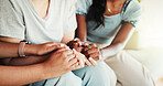 Women, talking and holding hands with discussion on sofa for care, support group or intervention at home. Closeup, female people or listening with friends on couch for confession, empathy or sympathy