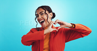 Buy stock photo Studio, happy woman and portrait with heart sign for love expression, affection and stylish outfit. Space, blue background and model with hands for gratitude, excited and fashion for valentines day