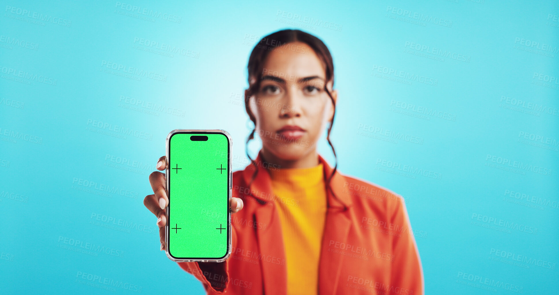 Buy stock photo Girl, portrait and phone with green screen in studio for announcement mockup, online awareness and activism. Woman, serious and chromakey display with tracking markers and message on blue background