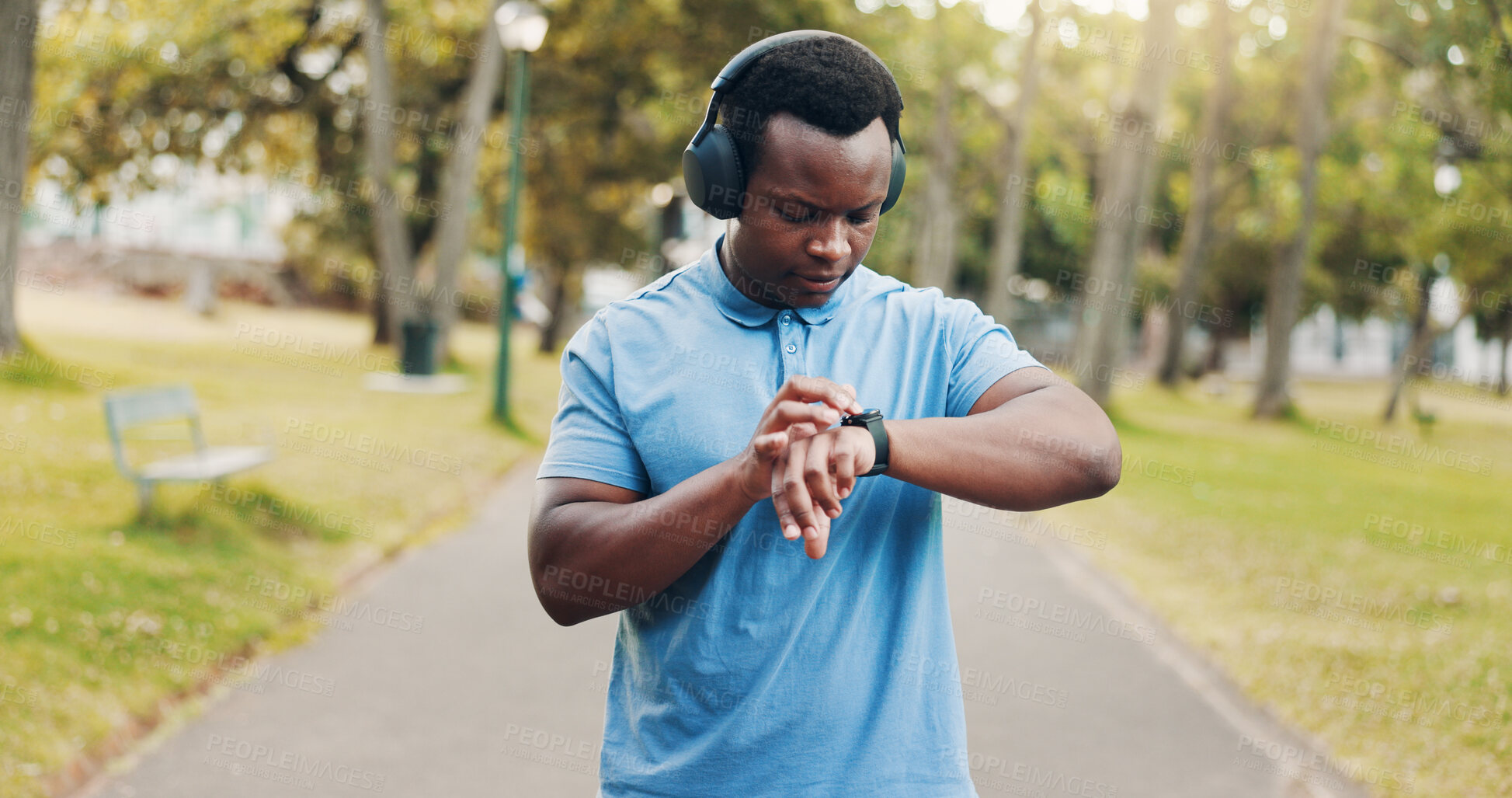 Buy stock photo Outdoor, black man and check smart watch for fitness, exercise steps or training performance. Park, wristwatch and sports athlete with workout results, heart rate and health with headphones for music