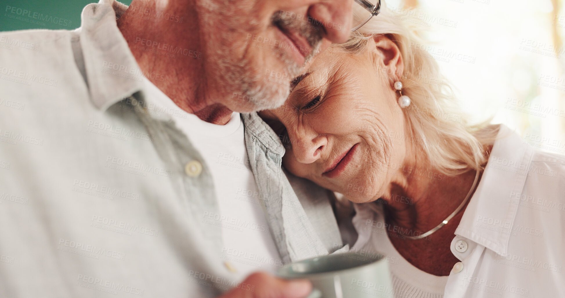Buy stock photo Senior couple, hug and tea in home, love and enjoying affection with happy wife in kitchen. Elderly people, smile and support with embrace for healthy marriage, coffee cup and retirement commitment