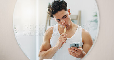 Buy stock photo Mirror, brushing teeth and man in bathroom, smartphone and morning with routine, habit and dental hygiene. Person, house and guy with cellphone, wellness and oral health with reflection or app