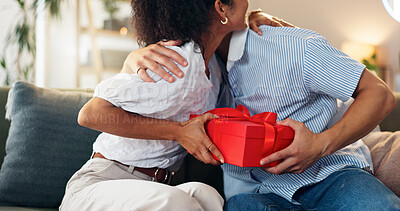 Buy stock photo Love, gift and hug with couple on sofa for valentines day celebration, box or bonding. Relationship, thank you and romance with man and woman at home for support, connection or present together