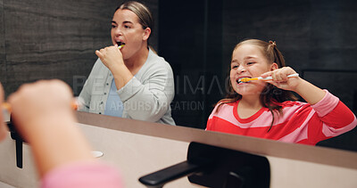 Buy stock photo Mother, girl and brushing teeth with smile in bathroom mirror, learning and dental wellness in home. Woman, child and toothbrush for cleaning mouth, health and teaching for oral care at family house