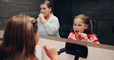 Buy stock photo Mom, girl and brushing teeth with smile in bathroom mirror, learning and dental wellness in home. Woman, child and toothbrush for cleaning mouth, health and teaching with oral care at family house