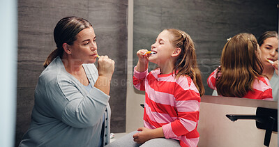 Buy stock photo Mother, girl and brushing teeth with learning in bathroom, hygiene and dental wellness in home. Woman, child and toothbrush for cleaning mouth, health and oral care with teaching at family house