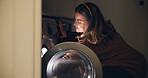 Woman, laundry and packing with washing machine at night for cleaning, housekeeping or chores at home. Female person, maid or cleaner working late for organizing clothing, garments or fabric at house