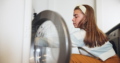 Buy stock photo Girl, laundry and packing with washing machine for housekeeping, chores or sorting fabric at home. Female person, teenager or organizing clothing with garments for texture, softener or tidying house