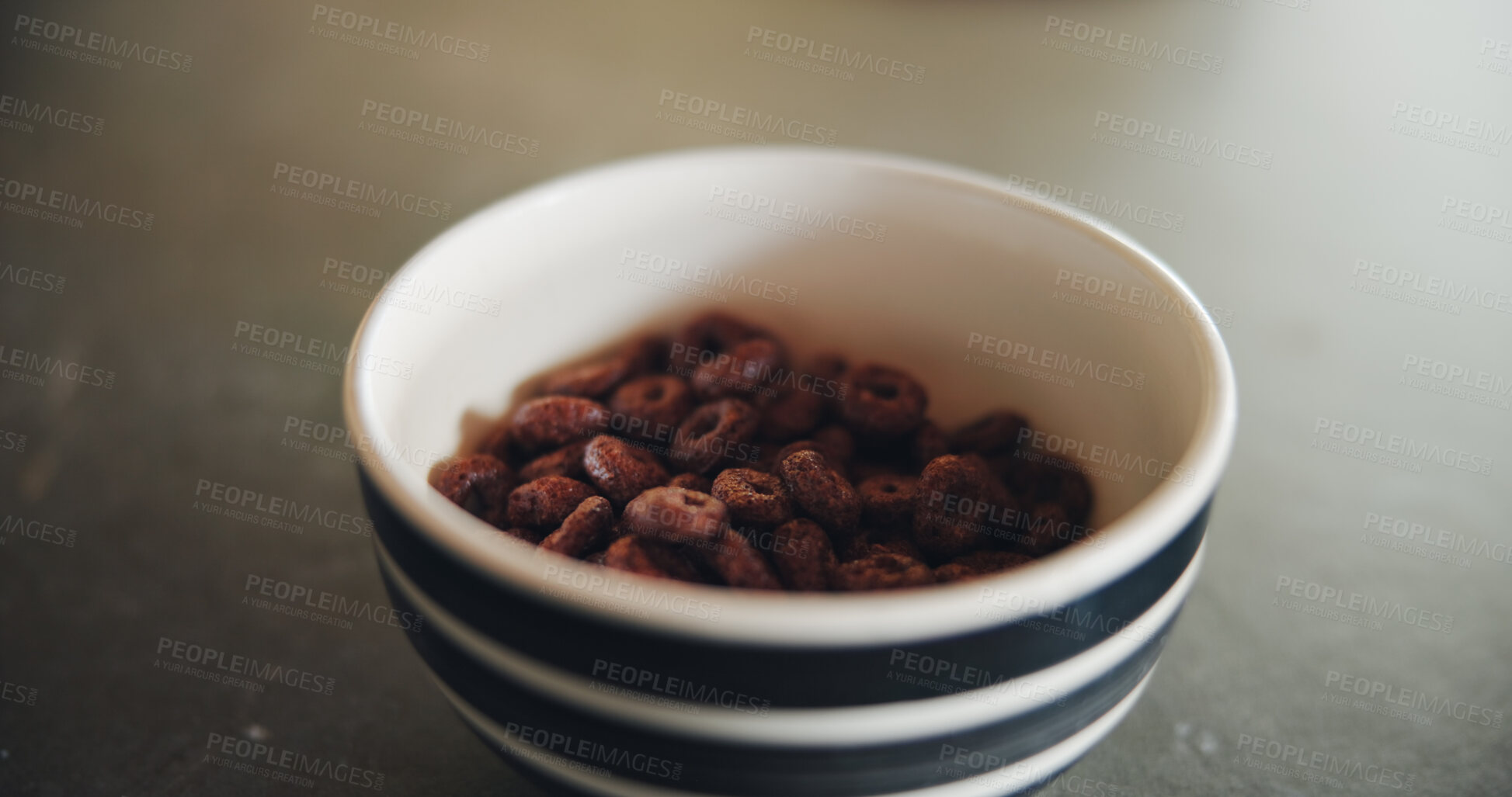 Buy stock photo Kitchen counter, bowl and cereal in morning for breakfast, nutrition and fiber for meal on table. Food, home and closeup of chocolate porridge for vitamins, protein and wellness for snack in house