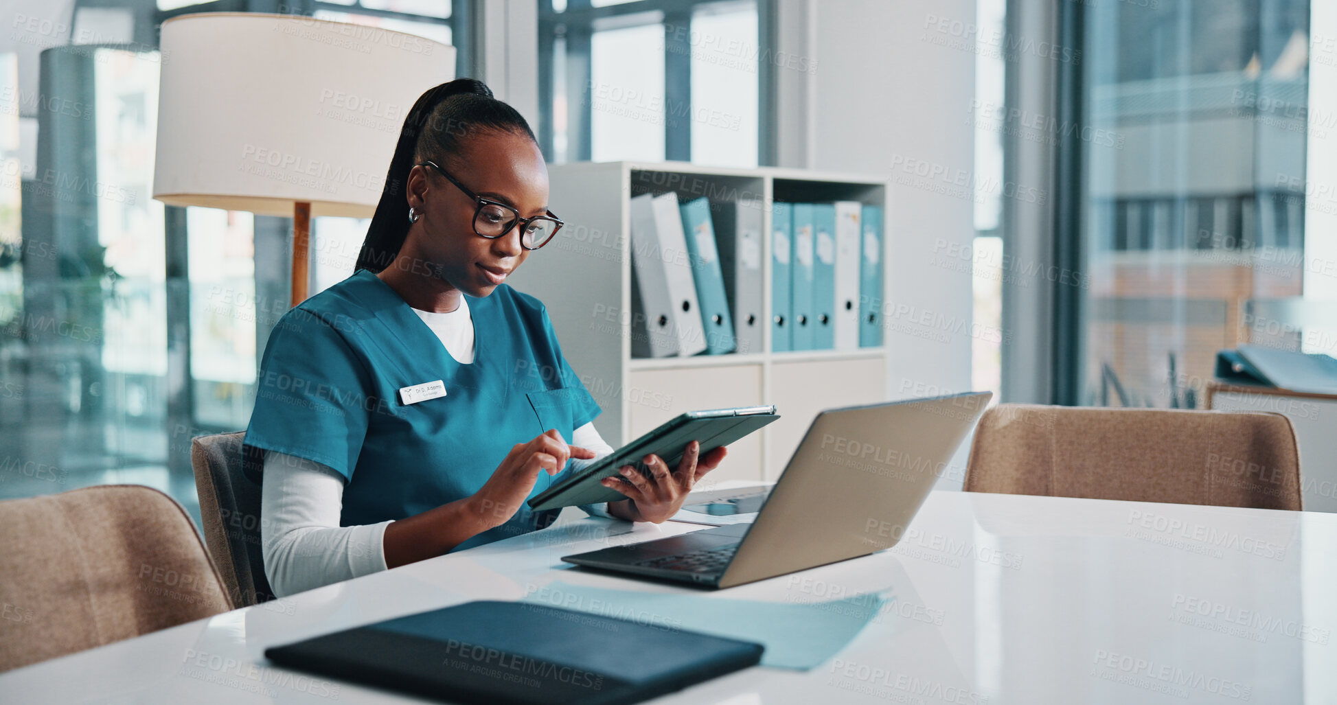 Buy stock photo Black woman, doctor and typing with tablet at hospital for research, laboratory results and medical report. Person, online and reading email for telehealth, schedule update and treatment information