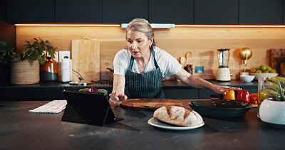Buy stock photo Home, tablet and woman in kitchen, online reading or ingredients with nutrition, bread or chef. Senior person, apartment and baker with tech, internet and research for recipe, food and connection