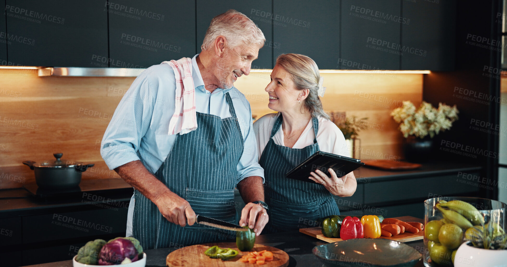 Buy stock photo Love, cooking and mature couple with vegetables, kitchen and bonding with ingredients for cuisine in home. Healthy food, helping or people with tablet for research, recipe or culinary skills in house