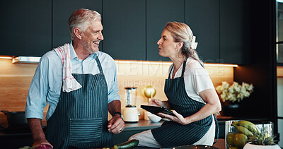 Buy stock photo Tablet, senior couple and cooking in kitchen with online tutorial, recipe and organic food guide in home. Man, woman and technology for meal preparation with vegetables, talk or laugh in retirement
