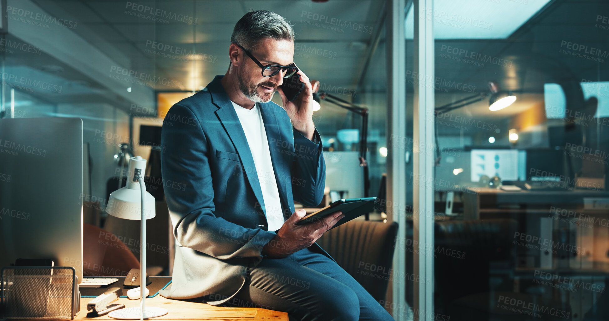 Buy stock photo Mature man, tablet and phone call with office, overtime work or project feedback. Web design, night or email update for programmer, cloud computing and research negotiation or online communication