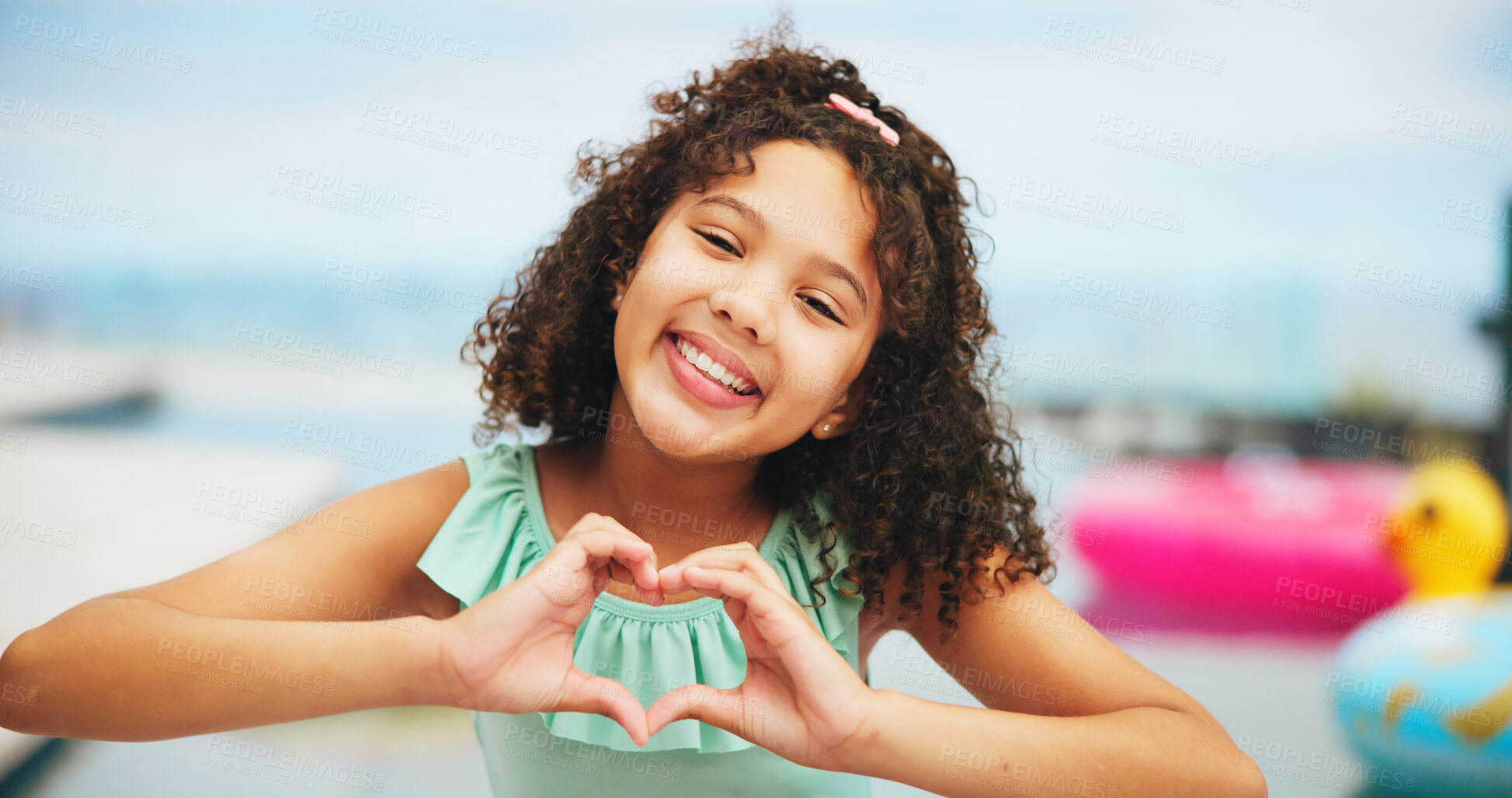 Buy stock photo Happy girl, portrait and pool with heart hands for summer vacation, holiday or swim at resort. Female person, child or kid with smile, emoji or shape for love, care or support at luxury getaway