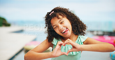 Buy stock photo Portrait, heart hands and outdoor with girl, funny face and swimming pool with vacation. Summer holiday, kid and child with gesture for love, tongue out and kindness with trust, support and happiness