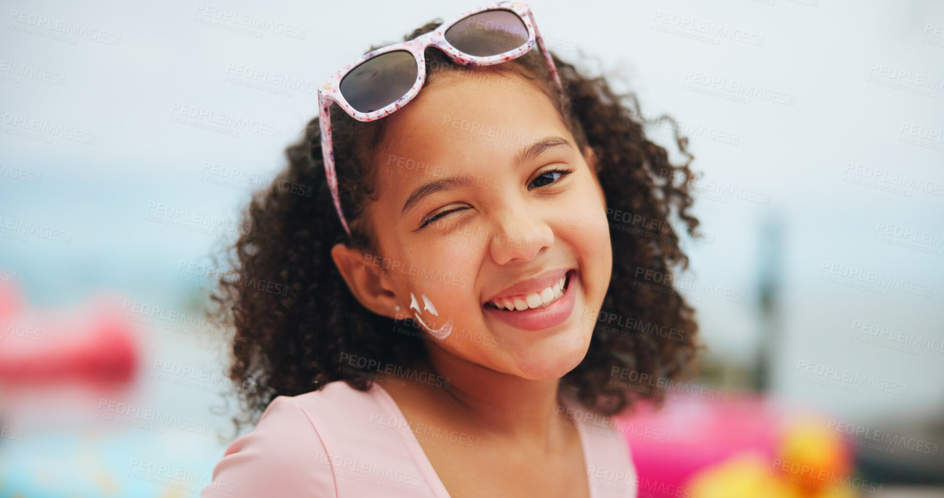 Buy stock photo Outdoor, child and wink with sunscreen for skincare, sunburn prevention and sunglasses on vacation. Holiday, fashion shades and girl face with spf cream for dermatology, UV protection and portrait