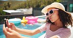 Happy girl, pool and summer fashion with selfie for photography, picture or memory at luxury resort. Female person, child or kid with sunglasses or hat for capture, social media or holiday vacation