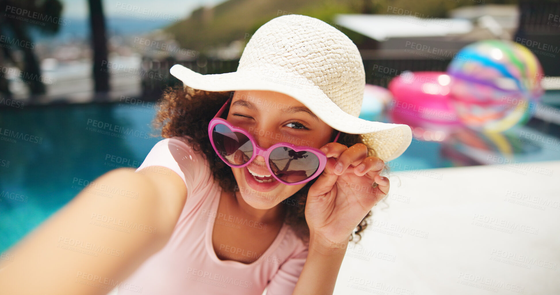 Buy stock photo Portrait, child and sunglasses with wink for selfie, vacation holiday and picture for memories outdoor. Pool, happy girl and hat with shades for fashion, photography and positive vibes for travel