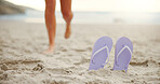 Person, feet or slippers with beach sand for walk, summer fun or outdoor vacation in nature. Closeup, shoes or sandals with tourist on sandy shore for holiday, tropical getaway or catching sun at sea